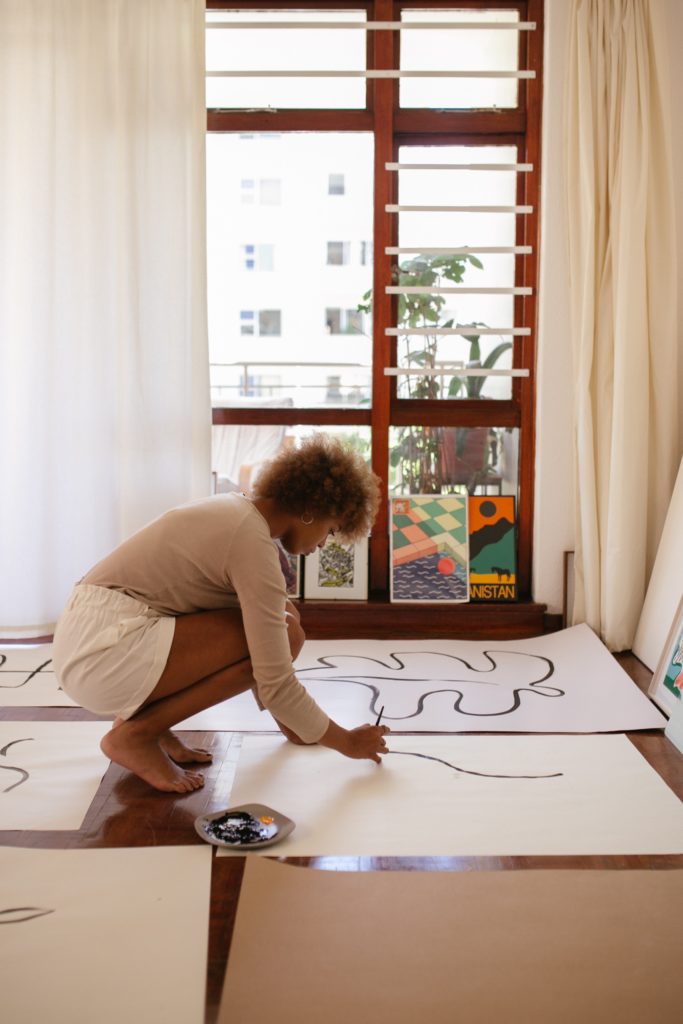 photo of woman painting on white canvas with talent